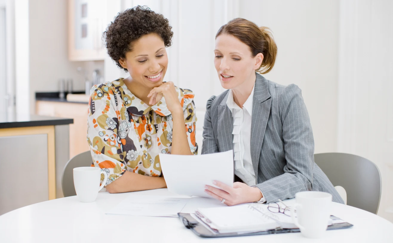 Colleagues reviewing paperwork together over coffee